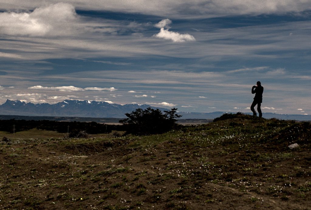 a man and his camera in front of amazing landscape
